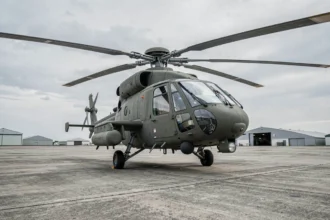 Hélicoptère militaire moderne sur tarmac de base aérienne avec avionique avancée visible dans le cockpit